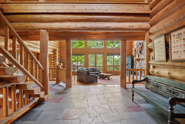 6070 Pilger Ave NW, Annandale, MN 55302 - living room featuring stone tile flooring, rustic walls, and stairs
