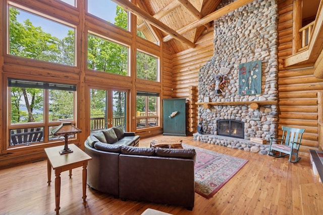 6070 Pilger Ave NW, Annandale, MN 55302 - living area with high vaulted ceiling, log walls, a fireplace, hardwood / wood-style floors, and wood ceiling with exposed beams
