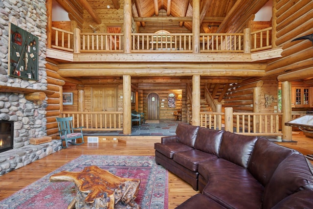 6070 Pilger Ave NW, Annandale, MN 55302 - living room featuring a towering ceiling, wood-type flooring, wood ceiling with exposed beams, a fireplace, and rustic walls