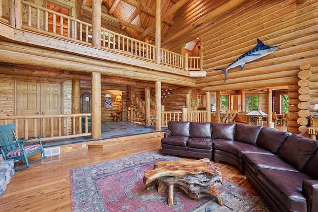 6070 Pilger Ave NW, Annandale, MN 55302 - living area featuring a towering ceiling, hardwood / wood-style floors, and log walls