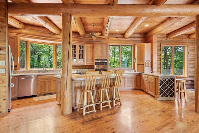 6070 Pilger Ave NW, Annandale, MN 55302 - kitchen featuring appliances with stainless steel finishes, wooden ceiling with exposed beams, light wood finished floors, a breakfast bar, and a sink