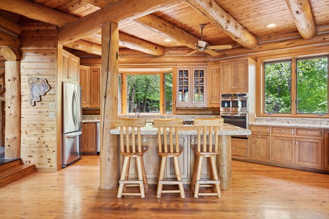 6070 Pilger Ave NW, Annandale, MN 55302 - kitchen with stainless steel appliances, wooden ceiling with exposed beams, light wood finished floors, a kitchen island, and a kitchen bar