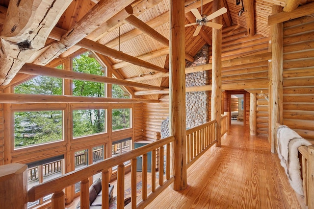 6070 Pilger Ave NW, Annandale, MN 55302 - corridor with log walls, light wood-style floors, wooden ceiling with exposed beams, high vaulted ceiling, and plenty of natural light