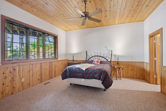 6070 Pilger Ave NW, Annandale, MN 55302 - carpeted bedroom with a wainscoted wall, wooden walls, wood ceiling, and a ceiling fan