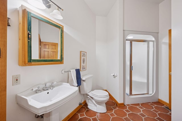 6070 Pilger Ave NW, Annandale, MN 55302 - bathroom with a shower stall, baseboards, toilet, and a sink