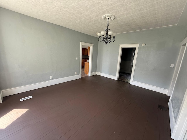 300 4th St SW, Little Falls, MN 56345 - empty room featuring a chandelier, dark wood finished floors, and baseboards