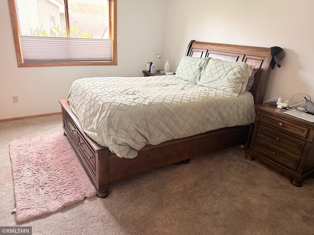 bedroom featuring baseboards and carpet