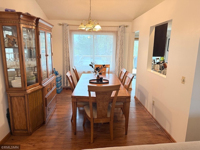 dining space with baseboards, wood finished floors, a notable chandelier, and vaulted ceiling