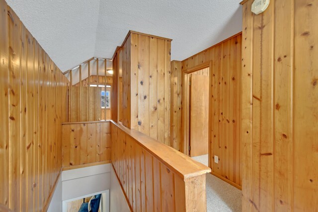1759 Flandrau St, Maplewood, MN 55109 - staircase with a textured ceiling, wooden walls, carpet, and vaulted ceiling