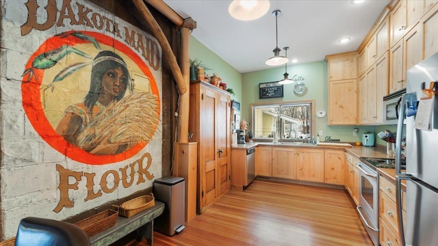 1007 Van Dyke Rd NW, Alexandria, MN 56308 - kitchen with light brown cabinetry, stainless steel appliances, light wood finished floors, light countertops, and pendant lighting