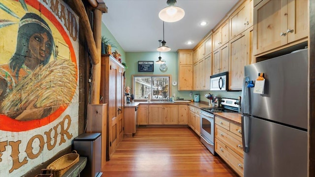 1007 Van Dyke Rd NW, Alexandria, MN 56308 - kitchen with appliances with stainless steel finishes, light brown cabinets, light wood finished floors, decorative light fixtures, and recessed lighting
