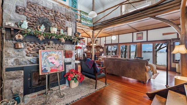 1007 Van Dyke Rd NW, Alexandria, MN 56308 - living room featuring a towering ceiling, a fireplace, hardwood / wood-style flooring, and a water view