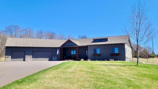 ranch-style house with a garage, a front lawn, driveway, and stone siding