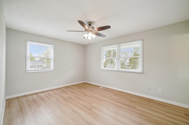 unfurnished room with light wood finished floors, ceiling fan, and baseboards