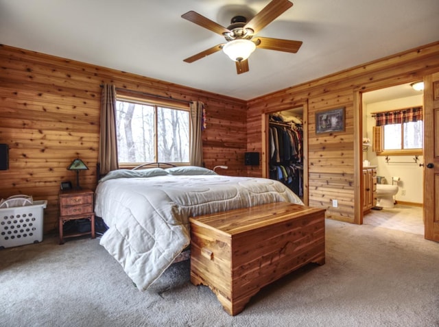 bedroom with light colored carpet, a closet, a spacious closet, and multiple windows
