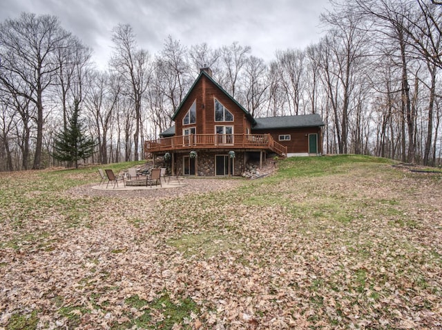 rear view of house featuring a deck, a patio area, stairway, a yard, and a fire pit