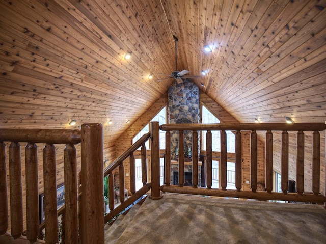 stairs with a ceiling fan, vaulted ceiling, wooden ceiling, and carpet