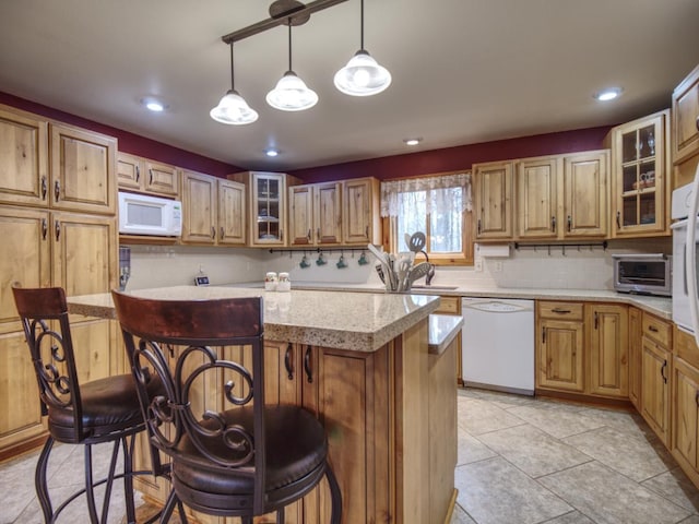 kitchen featuring a kitchen breakfast bar, backsplash, a center island, a toaster, and white appliances