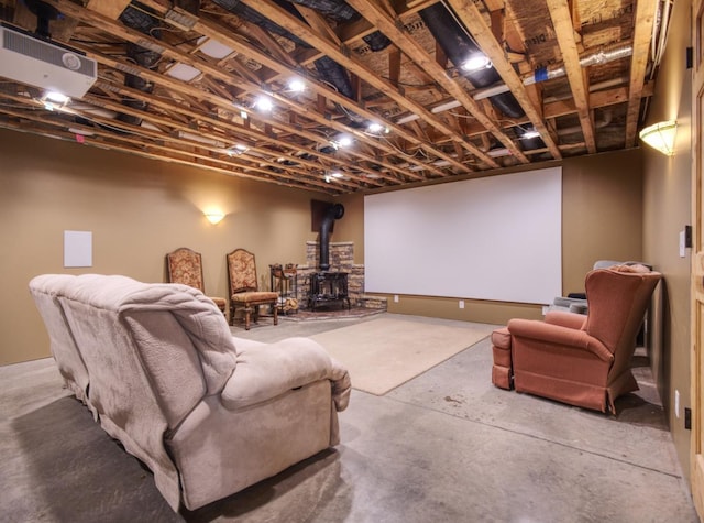 home theater with a wood stove and unfinished concrete floors
