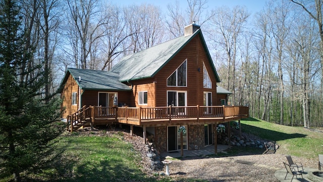 rear view of property with a patio area, a deck, and a lawn