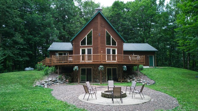 14534 290th Ave, Sampson Twp, WI 54757 - rear view of property featuring an outdoor fire pit, a wooden deck, a patio, and a yard