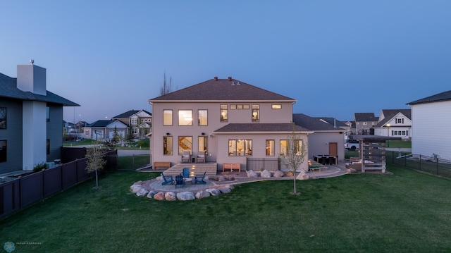back of property at dusk featuring a patio area and a residential view