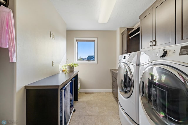 2704 1st St E, West Fargo, ND 58078 - washroom with cabinet space, washer and clothes dryer, baseboards, and light tile patterned floors