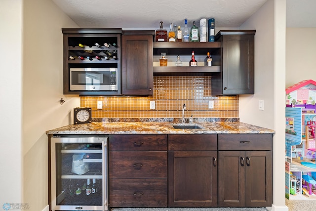 2704 1st St E, West Fargo, ND 58078 - indoor wet bar with wine cooler, stainless steel microwave, and decorative backsplash