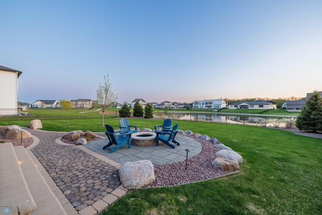 2704 1st St E, West Fargo, ND 58078 - yard at dusk featuring a water view, a patio area, a fire pit, and a residential view