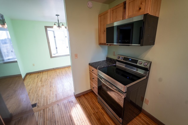 kitchen with light wood-type flooring, a healthy amount of sunlight, and stainless steel appliances