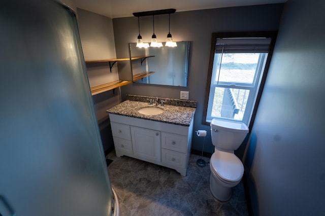 bathroom with toilet, vanity, and baseboards