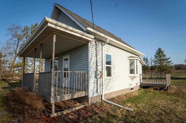 view of home's exterior with a wooden deck and a lawn