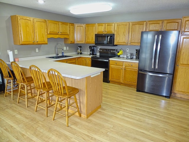 N1698 945th St, Rock Creek Twp, WI 54701 - kitchen featuring light countertops, light wood-type flooring, a sink, and black appliances