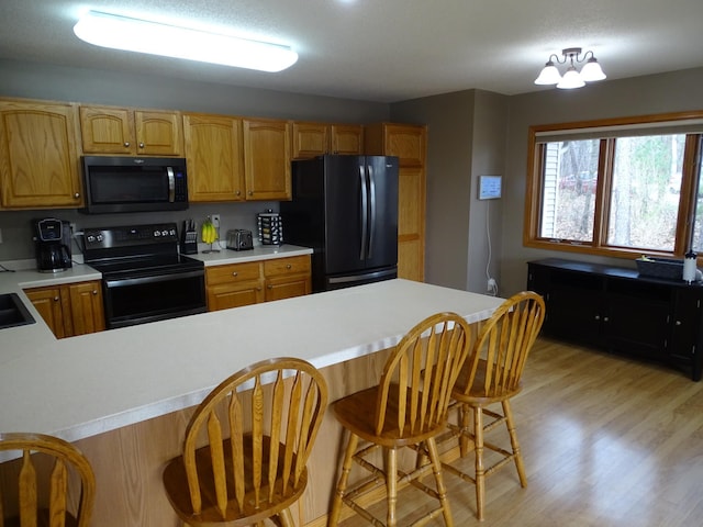 N1698 945th St, Rock Creek Twp, WI 54701 - kitchen with light countertops, light wood-type flooring, and black appliances
