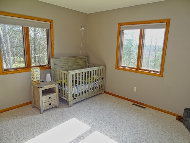 N1698 945th St, Rock Creek Twp, WI 54701 - carpeted bedroom with baseboards, a crib, and visible vents