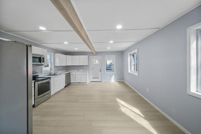 115 Prentice St, Clayton, WI 54004 - kitchen featuring light wood finished floors, light countertops, baseboards, appliances with stainless steel finishes, and white cabinetry