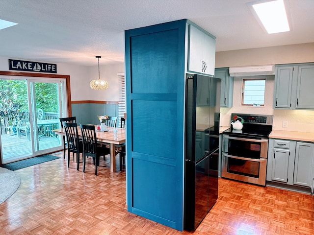 5060 Condons St SE, Prior Lake, MN 55372 - kitchen with double oven range, a chandelier, a wainscoted wall, freestanding refrigerator, and plenty of natural light