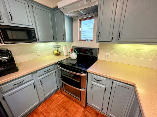 5060 Condons St SE, Prior Lake, MN 55372 - kitchen with black microwave, range with two ovens, exhaust hood, and tasteful backsplash