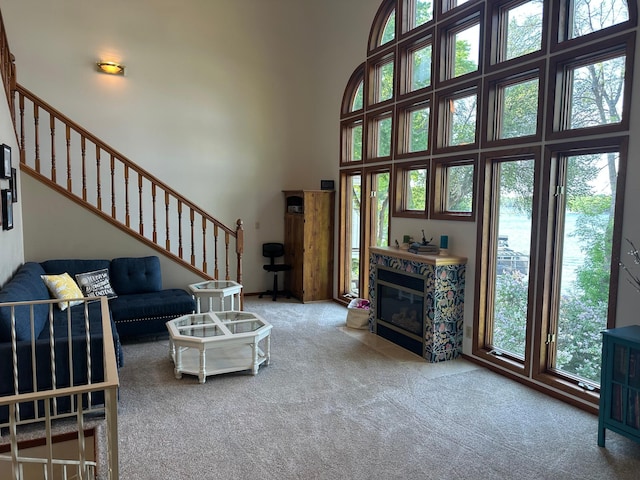 5060 Condons St SE, Prior Lake, MN 55372 - carpeted living room featuring stairs, a high ceiling, and a fireplace with flush hearth