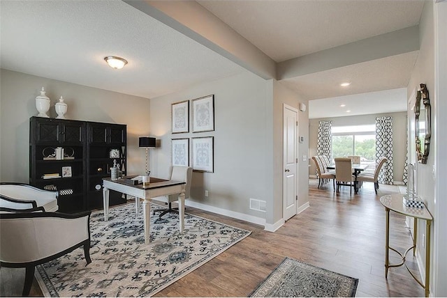 office with a textured ceiling, visible vents, wood finished floors, baseboards, and recessed lighting