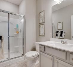 full bath with vanity, a stall shower, and toilet