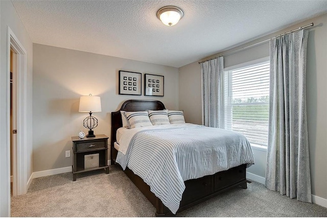 bedroom with a textured ceiling, baseboards, and light colored carpet