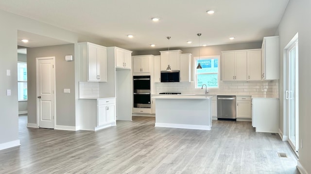 kitchen with visible vents, appliances with stainless steel finishes, tasteful backsplash, light countertops, and light wood finished floors