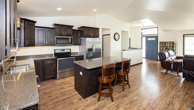 3497 50th St S, Fargo, ND 58104 - kitchen with stainless steel appliances, a sink, vaulted ceiling, open floor plan, and light wood-type flooring