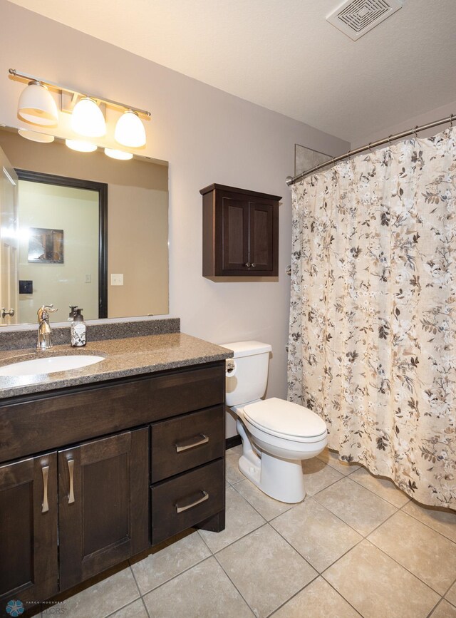 3497 50th St S, Fargo, ND 58104 - full bath featuring tile patterned flooring, toilet, vanity, and a shower with shower curtain