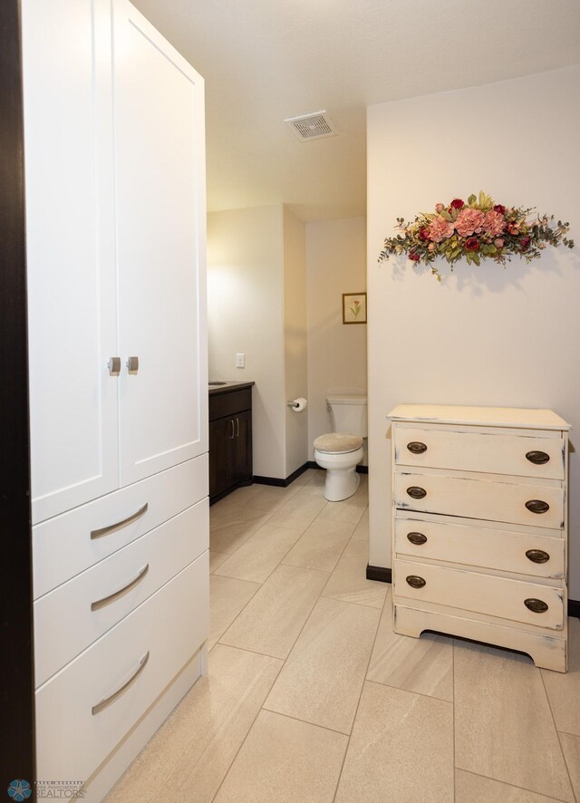 3497 50th St S, Fargo, ND 58104 - bathroom featuring toilet, tile patterned flooring, vanity, and baseboards