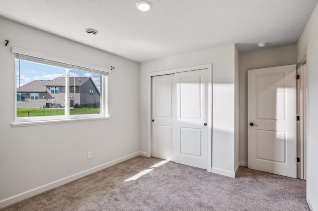 18872 Fillmore St NW, Elk River, MN 55330 - unfurnished bedroom with carpet floors, a closet, baseboards, and a textured ceiling