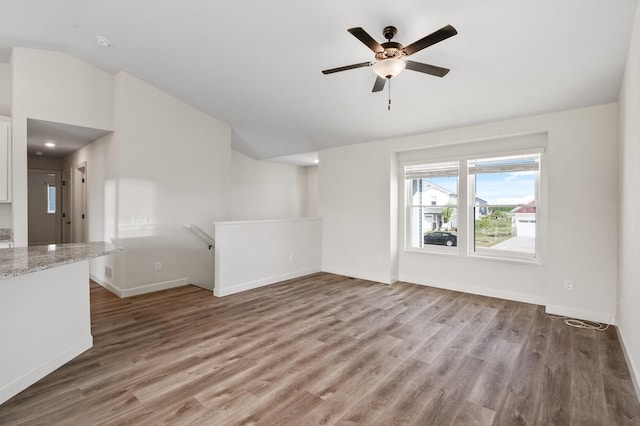 18872 Fillmore St NW, Elk River, MN 55330 - unfurnished living room featuring lofted ceiling, wood finished floors, baseboards, and ceiling fan