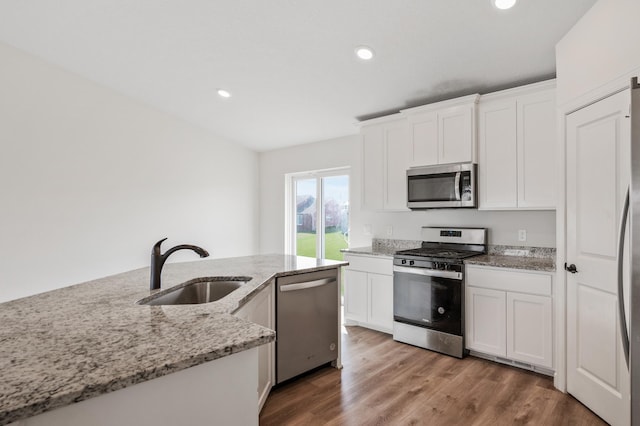 18872 Fillmore St NW, Elk River, MN 55330 - kitchen featuring appliances with stainless steel finishes, a sink, white cabinetry, recessed lighting, and light stone countertops