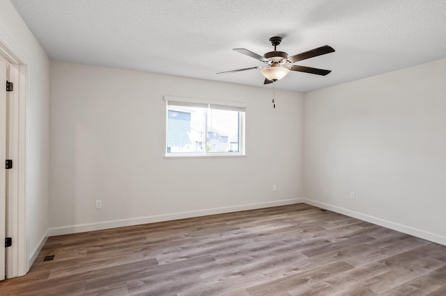 18872 Fillmore St NW, Elk River, MN 55330 - unfurnished room with a ceiling fan, wood finished floors, a textured ceiling, and baseboards